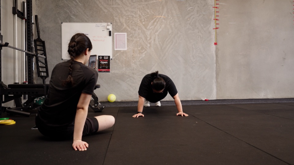 Two players work through floor events in the gym